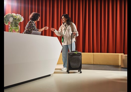 A woman is handed some keys by a hotel receptionist