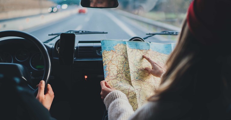 Couple travelling in car following route on road map