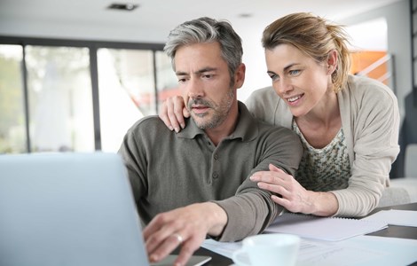 Couple looking at laptop reviewing financial services