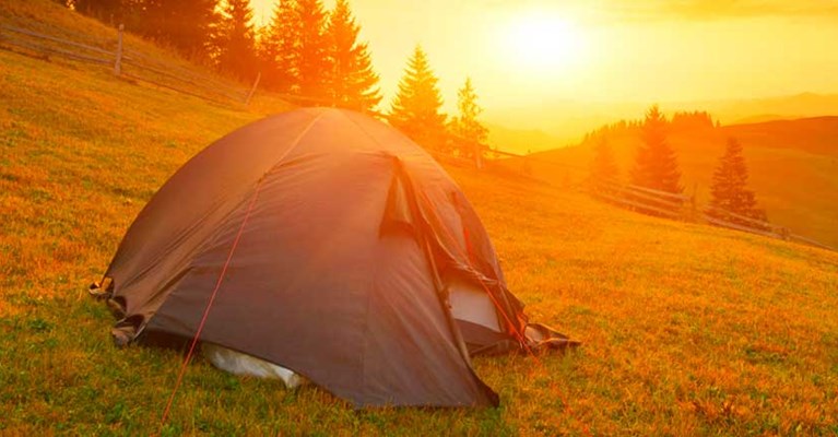 A tent outside at sunset