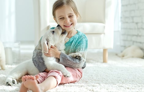 Little girl playing with a small puppy