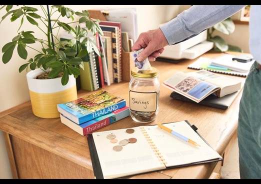 A man adds money to a savings jar