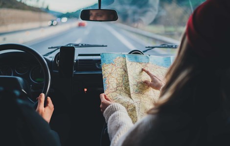 Couple travelling in car following route on road map