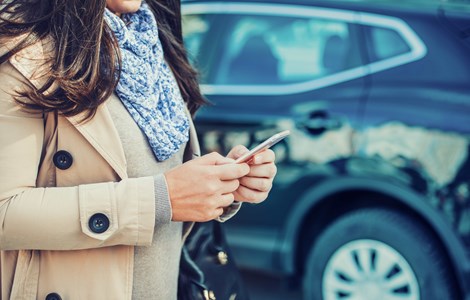 Woman on mobile phone buying car insurance for new car