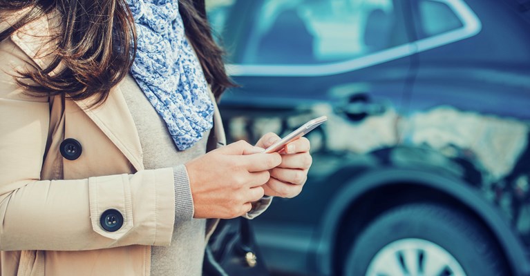 ผู้หญิงบนโทรศัพท์มือถือซื้อประกันภัยรถยนต์สำหรับรถใหม่