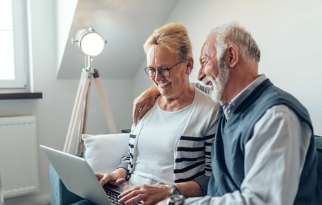 Older couple at home reviewing financial services on a laptop
