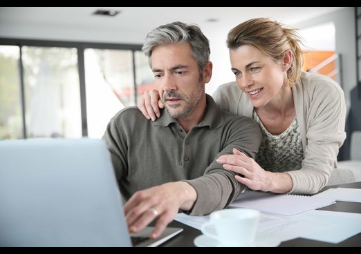 Couple looking at laptop reviewing financial services