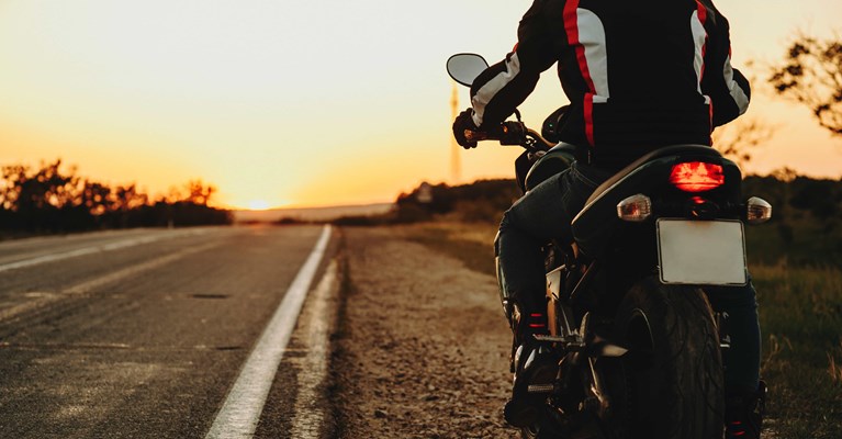 Rider sat on a motorbike by the side of the road