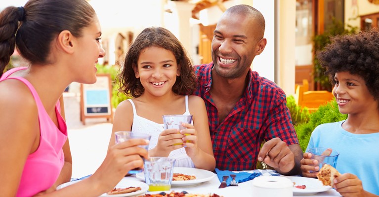 Happy family eating outdoors at a restaurant together