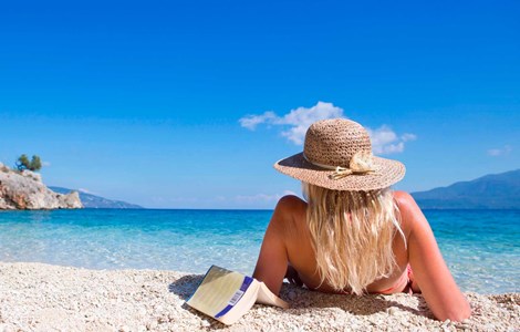 woman with a book by a beach