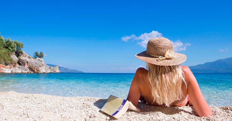 woman with a book by a beach