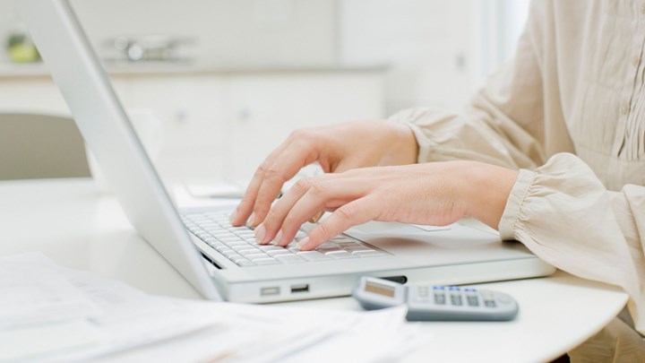 hands on a laptop, with calculator
