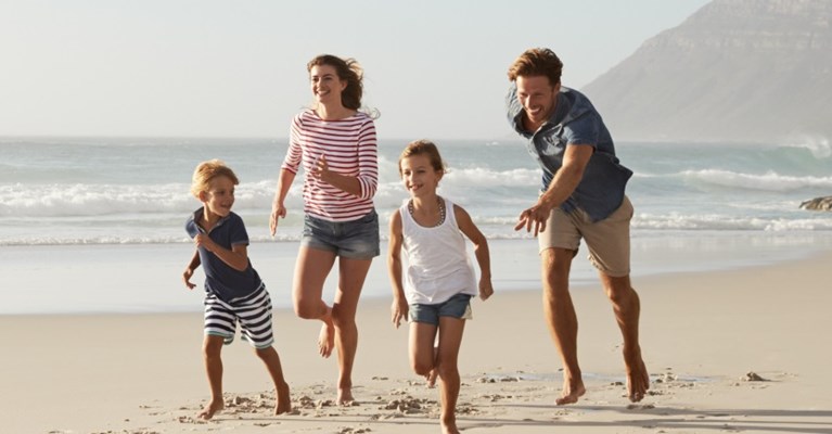 Family running on a beach