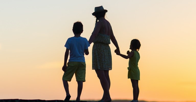 Family silhouetted against a sunset