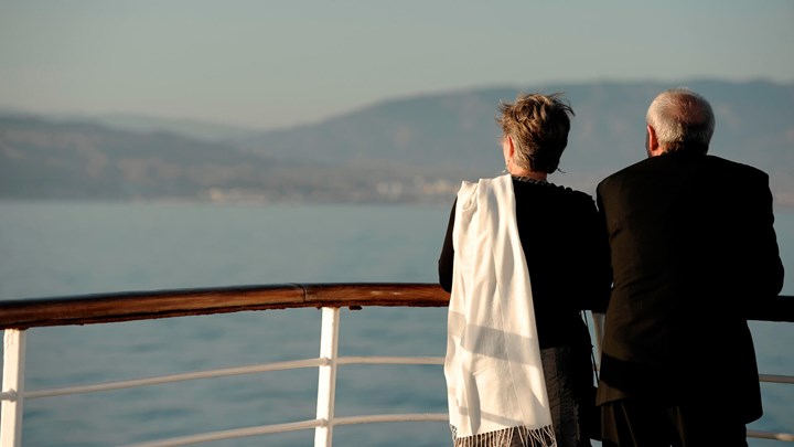 Older couple standing at the rail of a cruise ship