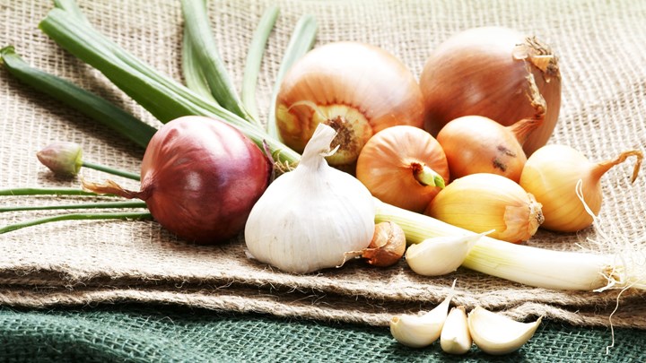 fresh garlic and other vegetables on burlap