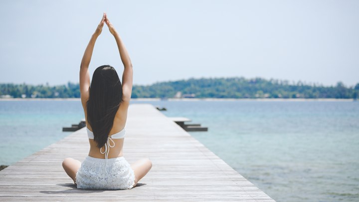 woman doing yoga on a pier