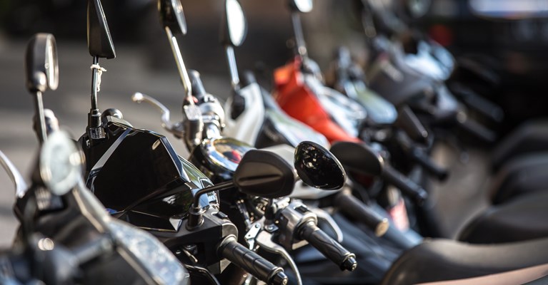 Brand new black, silver and orange motorbikes stood next to each other in a showroom