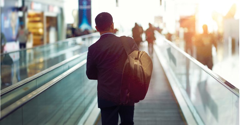 Man walking through airport on travelator 