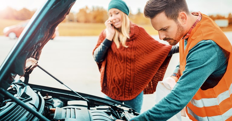 Couple with broken down car on the phone to recovery