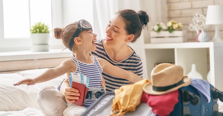 Mum and daughter packing suitcase for holiday