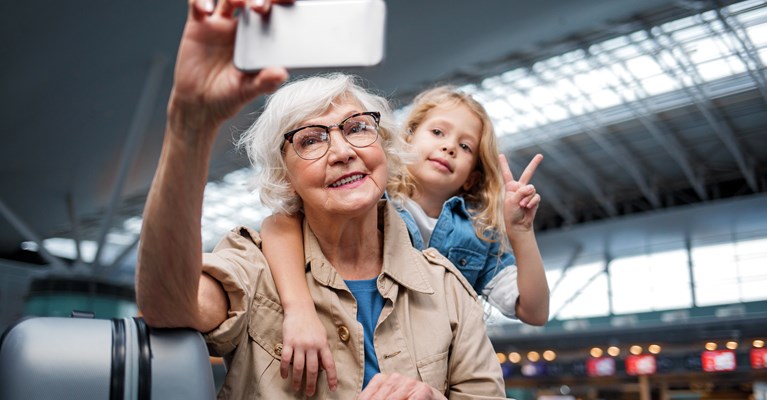 Grandma and granddaughter taking selfie in the airport