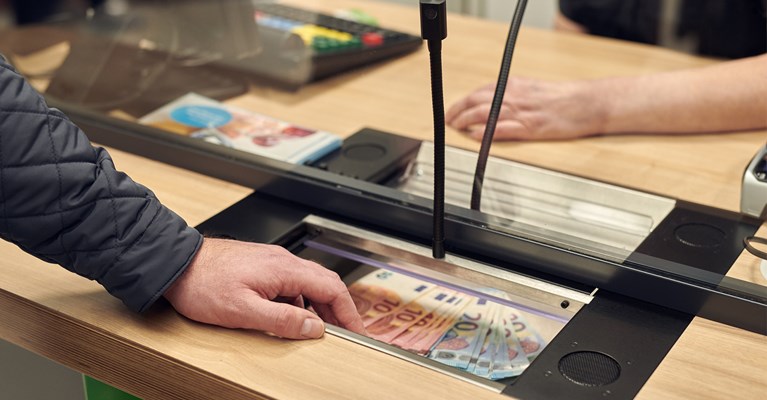 Customer picking up Euros in Asda travel money bureau