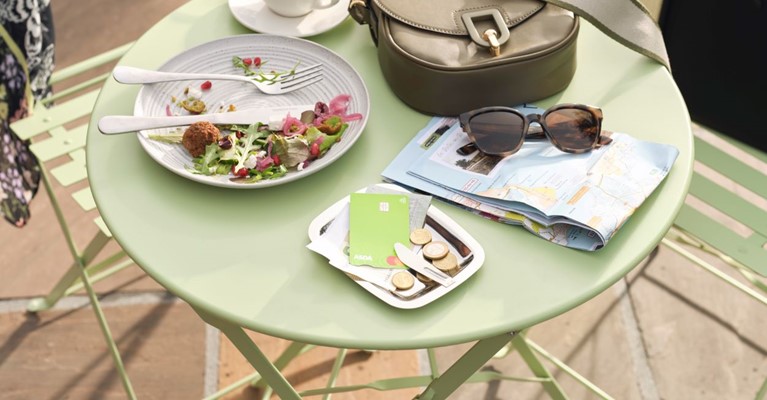 Couple paying for lunch with foreign currency and travel money card