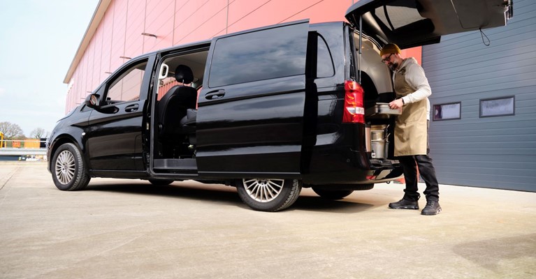 A man loading a parcel into a van