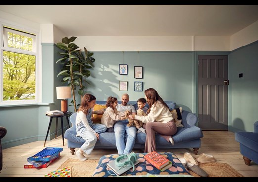 A young family sit on a sofa