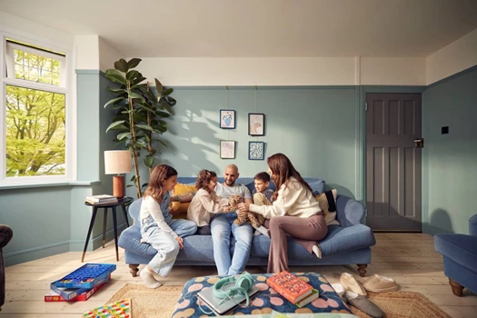 A young family sit on a sofa