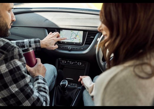 A couple sit in a car looking at the sat nav