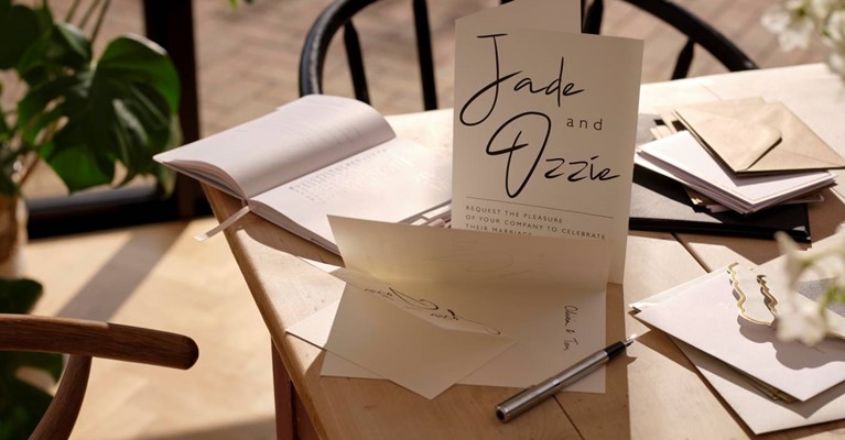 A wedding invitation is laid out on a table
