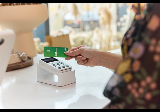 A person using an Asda Money Credit Card to pay at a contactless card reader
