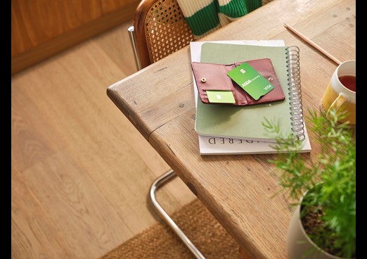 A table has a credit card laid out on top of a wallet