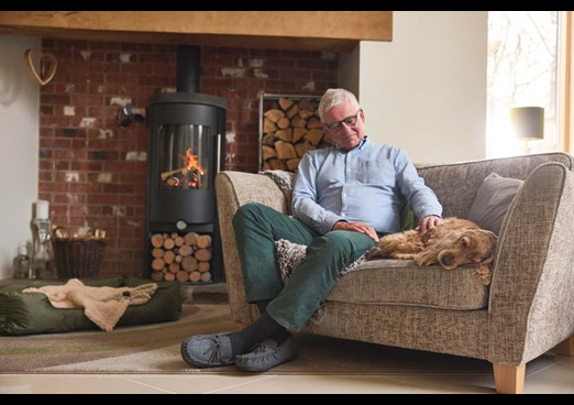 A dog and it's owner sat on a sofa